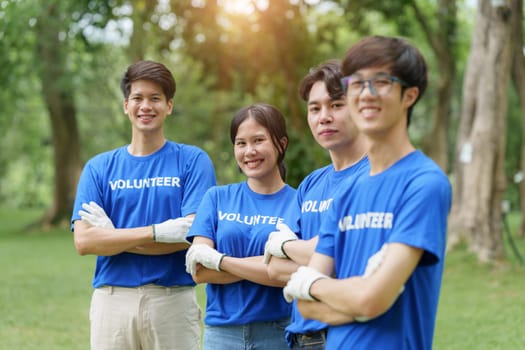 Young Asian Volunteers with garbage bags cleaning park area. Ecology, Charitable organization concept.