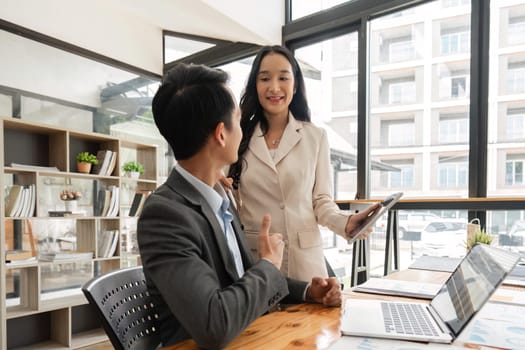 Happy businesspeople working together in the office while using laptop analyze the company finances and tax.