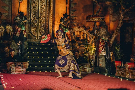 Balinese woman dancing in cultural show. Traditional balinese dances with colorful vestimentation