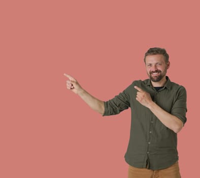 Man is depicted on a pink background, showcasing a dynamic and expressive gesture with his hands. He uses his hands to show arrows, indicating a sense of direction or movement. High quality photo