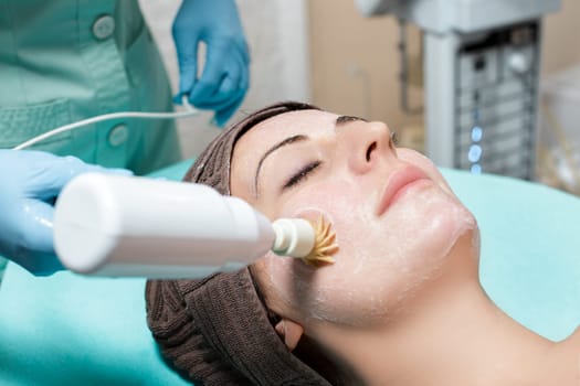 Mechanical peeling. Beautician makes mechanical cleaning of the face.