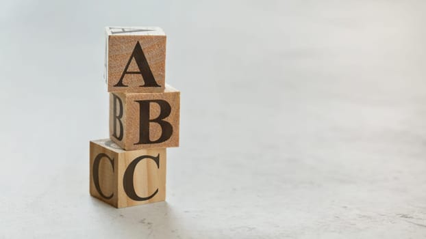 Pile with three wooden cubes - letters ABC on them, space for more text / images on right side.