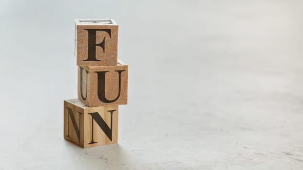 Pile with three wooden cubes - letters FUN on them, space for more text / images on right side.