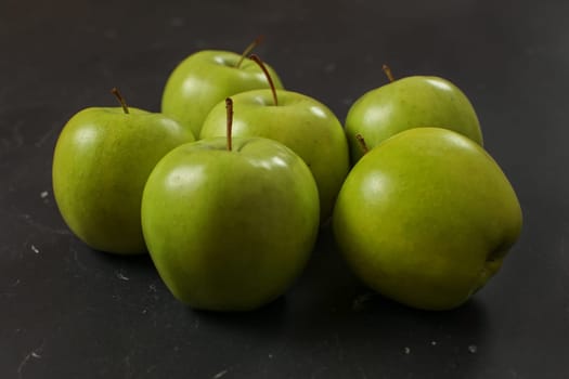 Green apples on black board.