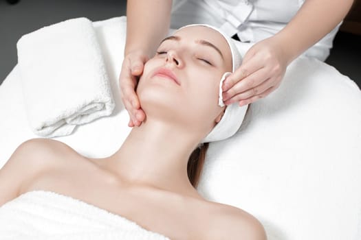 doctor beautician cleanses the skin woman with a sponge. Perfect cleaning - spa treatment skincare face.