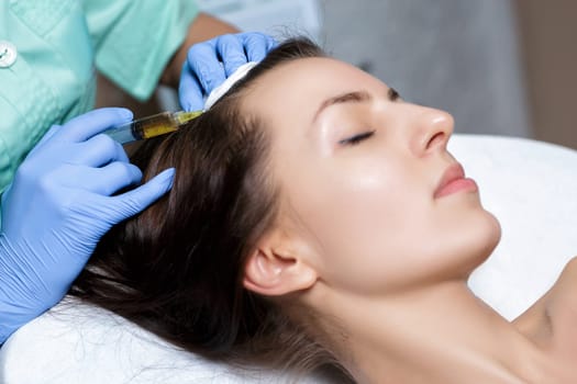 Needle mesotherapy. Cosmetic been injected in woman's head. Thrust to strengthen the hair and their growth