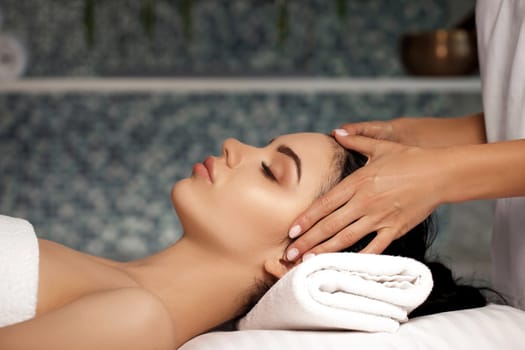 anti-aging facial massage. Woman receiving massage from masseur at Spa salon.