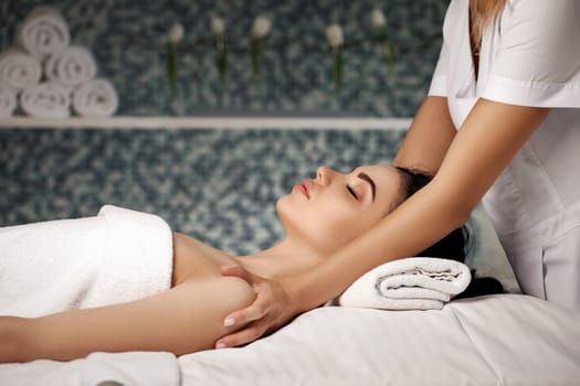 anti-aging facial massage. Woman receiving massage from masseur at Spa salon.