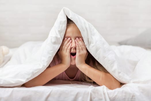 cute little child girl wakes up from sleep in bed in the morning