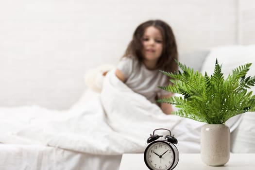 cute little child girl wakes up from sleep in bed in the morning