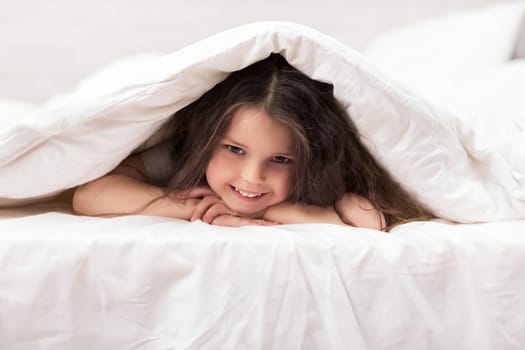 happy smiling morning baby in bed. child dabbles in bed