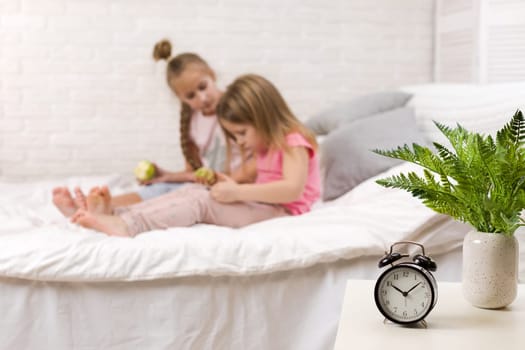 two cute children girls use digital tablet in bed. child playing on tablet pc.