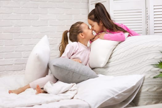 two cute children girls playing in the bedroom. pajama party and friendship.