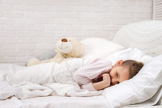 smiling little child girl sleeping in her bed