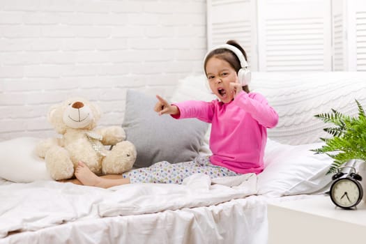little child baby girl listening to the music with the headphones. happy morning