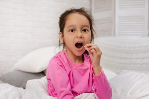 little child girl eat pill for treatment