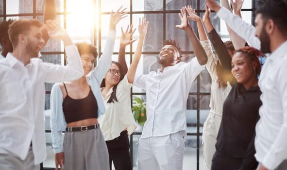 Raised up hands and arms of large group in seminar class room to agree with speaker at conference seminar meeting room