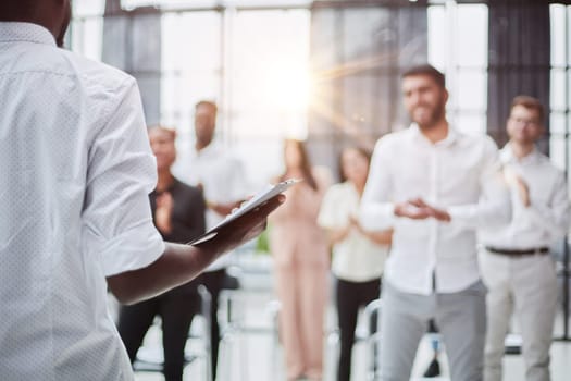 High angle view at multi-ethnic group of business people applauding standing up and smiling in audience at business conference or seminar