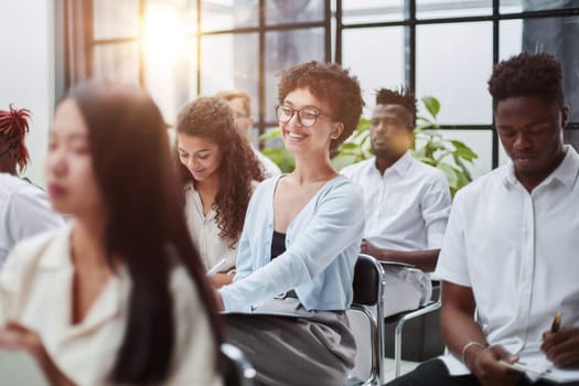 Businesspeople listening to business leader or trainer presenting project at the workplace.