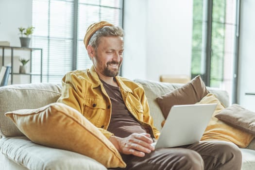 Happy client watches the result of freelancer's work on computer. Man with focused attention, he views outcome of the freelancer's efforts displayed on computer screen. . High quality photo