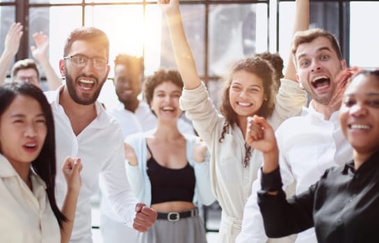 Raised up hands and arms of large group in seminar class room to agree with speaker at conference seminar meeting room