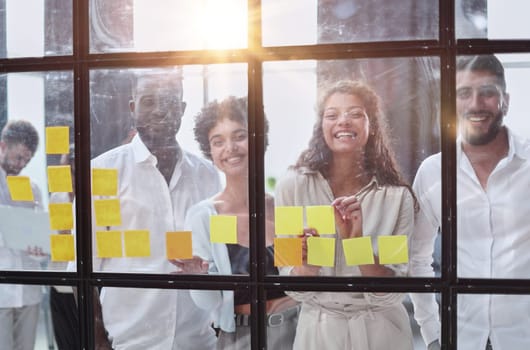 colleagues discuss and stick notes on the glass in the office