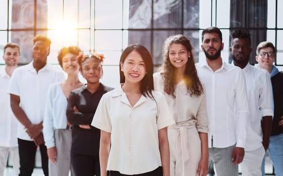 Happy diverse professional business team stand in office looking at camera