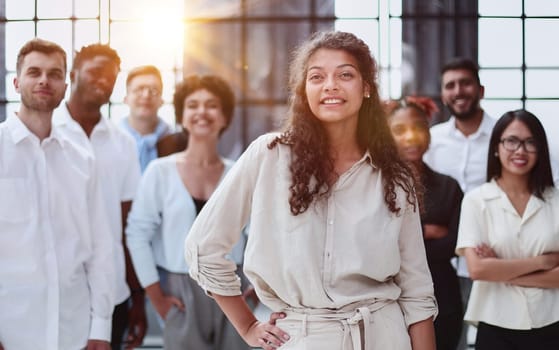 Happy diverse professional business team stand in office looking at camera