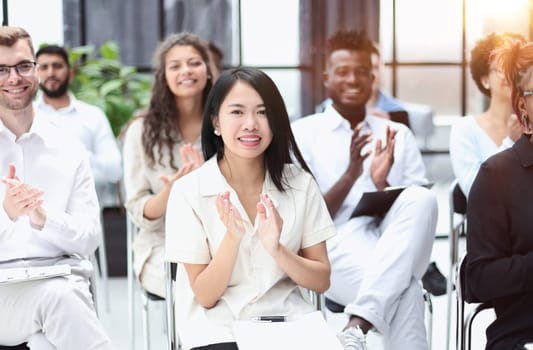 businesswoman applauding during seminar near interracial colleagues