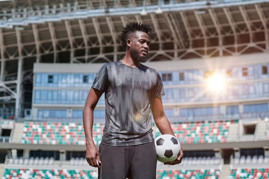 confident black football player holding the ball in his hand