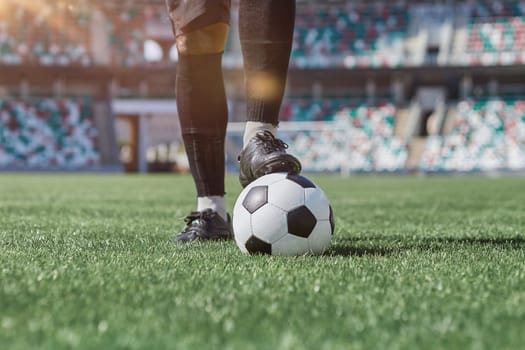 feet of soccer player tread on soccer ball in the stadium