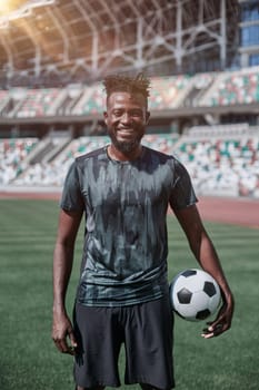 Intense portrait of a football player holding the ball in the stadium