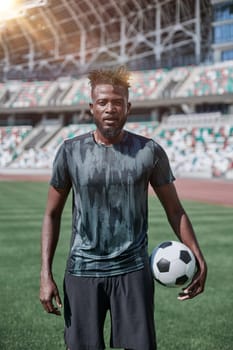 Intense portrait of a football player holding the ball in the stadium