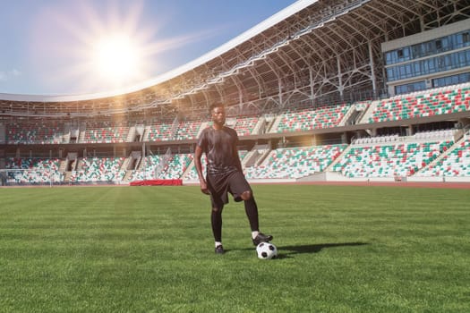 Man holding soccer ball with his foot in the stadium