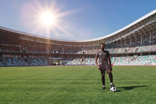 Man holding soccer ball with his foot in the stadium
