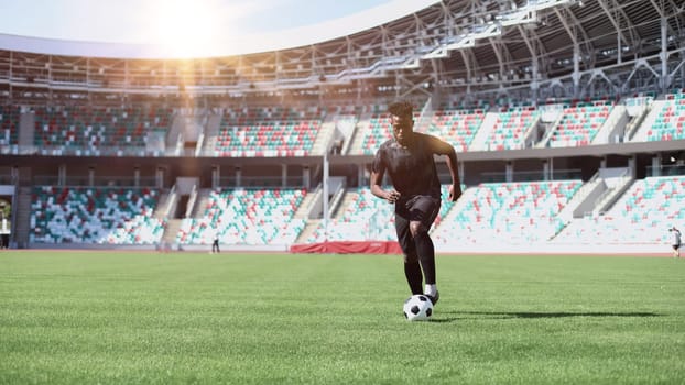 African American man playing football on the stadium field.