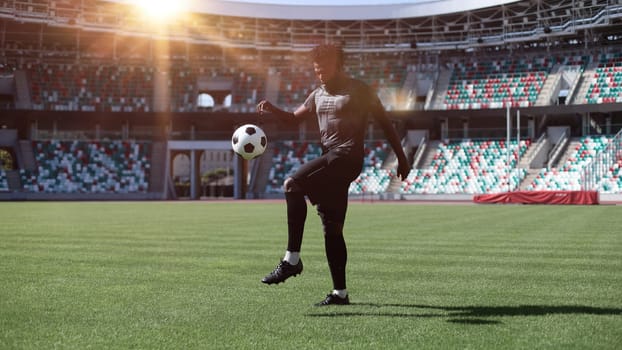 African American man playing football on the stadium field.