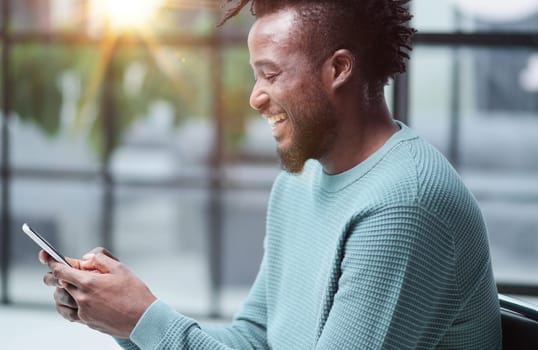 Black man looking at smartphone browsing internet, office technology and digital communication