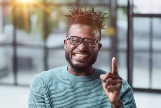 Portrait of a serious african american man, shaking his finger, warning and preventing you from something bad, looking at the camera with a worried expression.