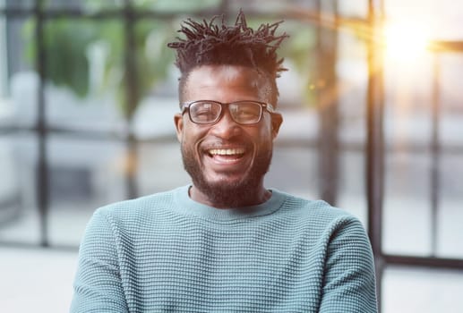 African American man in green sweater looking at camera