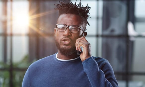 communication and technology concep african american businessman calling on smartphone at office