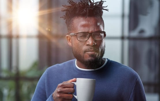 Portrait of a smiling CEO at workplace in a modern office in casual wear with glasses