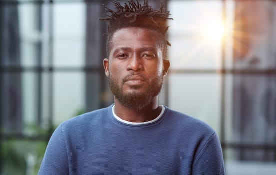 Handsome charming cheerful african american businessman in chic colorful casual clothes, in an office building
