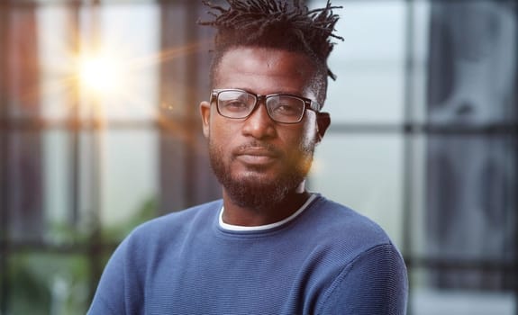 Portrait of a smiling CEO at workplace in a modern office in casual wear with glasses