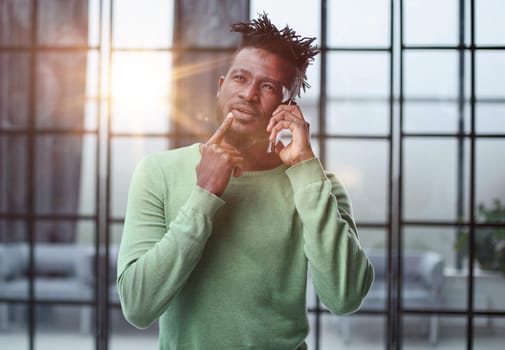 Businessman in office. Handsome man talking on phone at work.