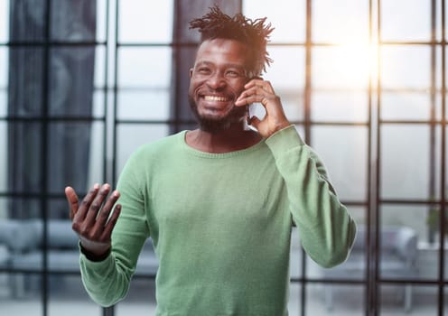 Businessman in office. Handsome man talking on phone at work.