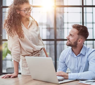 business lady looking at laptop with her colleague in the office