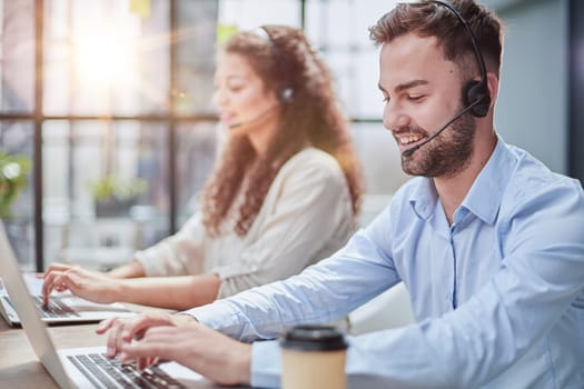 Handsome male customer service agent working in call center office as a telemarketer.