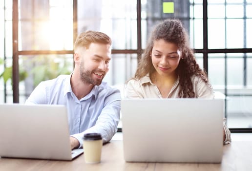 Group of business people working together on a business project in the office behind a laptop
