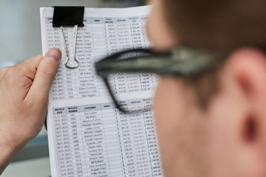 A male manager is reviewing marketing reports for the new campaign